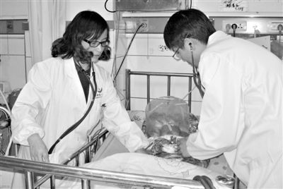 12月13日，常德市第一人民医院医护人员在重症病房为接种乙肝疫苗后出现不良反应的男婴进行检查。新华社发